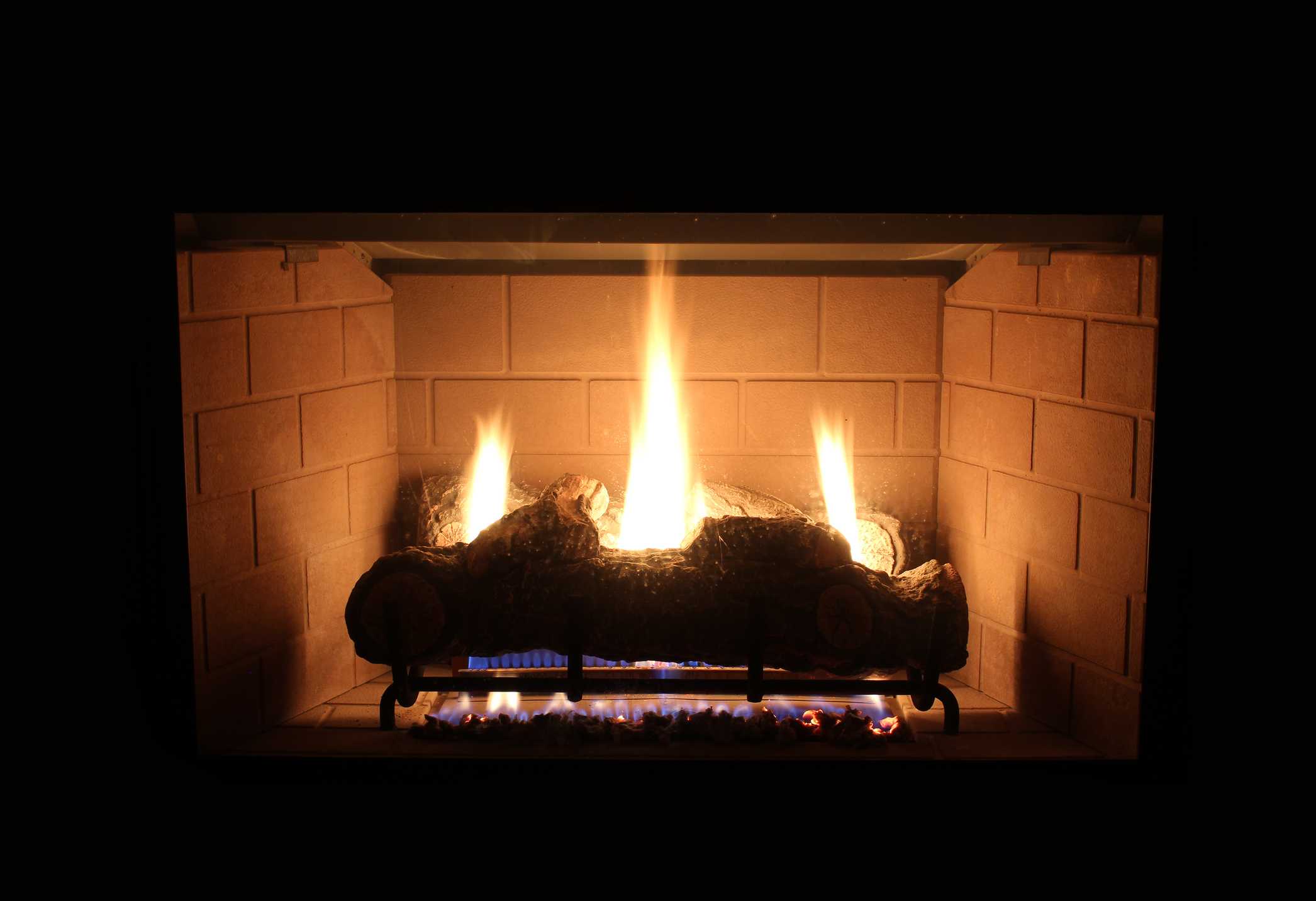 Realistic gas fireplace logs creating a cozy fire display in St. Louis, MO