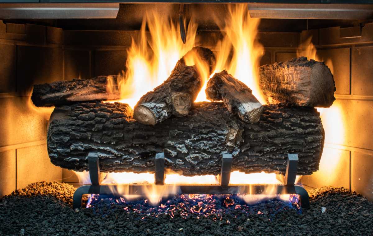 Gas fireplace logs burning with bright flames inside a fireplace in St. Louis, MO